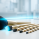 A set of luxurious gold-handled makeup brushes arranged on a clean white laboratory surface, illuminated by a soft blue UV-like light beam, with a blurred high-tech background.